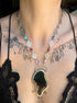 Necklace with a unique butterfly pendant worn by a person with tattoos on their neck.