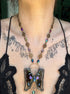 Butterfly pendant necklace on a person with tattoos